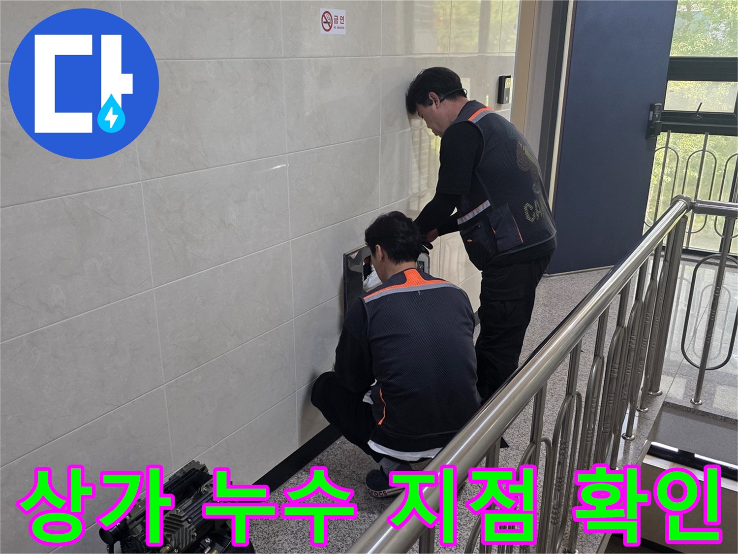 두 명의 기술자가 상가 건물 벽면의 누수 의심 부위를 정밀하게 조사하며 원인을 파악하고 있습니다-영업 손실을 최소화하기 위한 신속한 조치입니다.