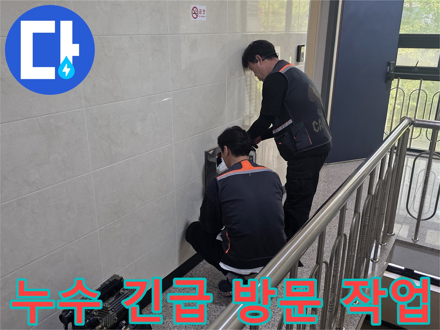 두 명의 전문 기술자가 건물 벽면의 누수 의심 지점을 정밀하게 탐지하며 긴급 상황에 신속하게 대응하고 있습니다-피해를 최소화하기 위한 빠른 조치입니다.