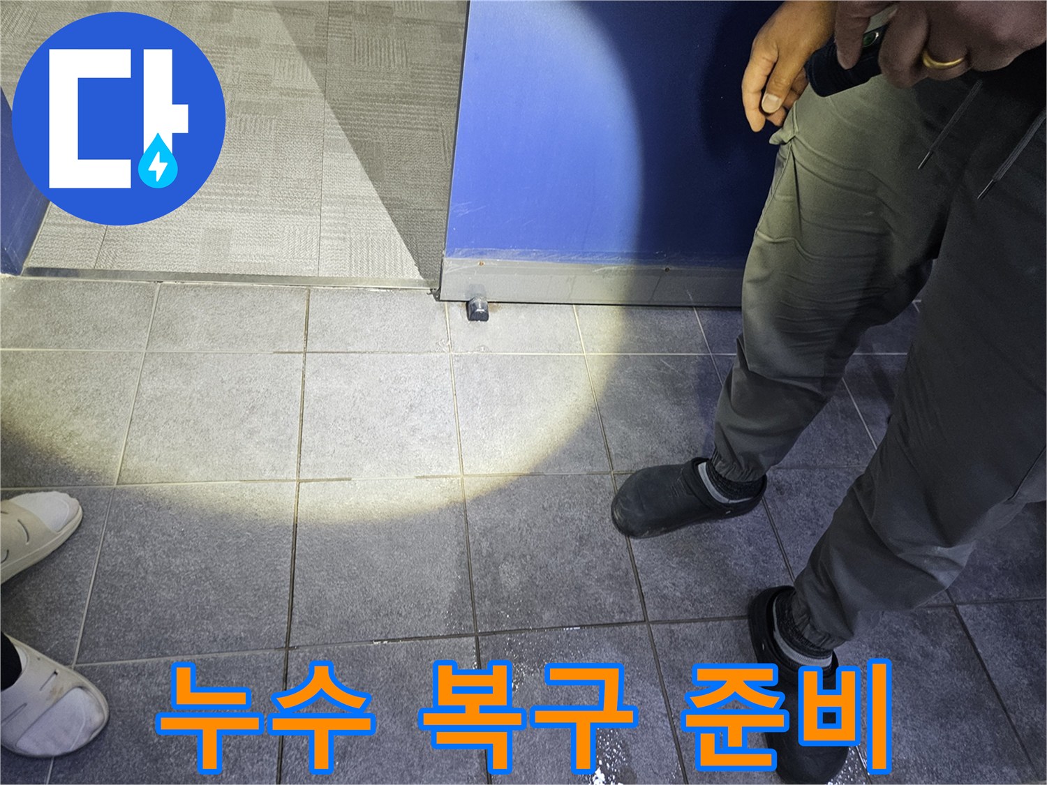 누수 전문가가 바닥에 고인 물기를 확인하며-누수 복구 작업을 위한 초기 현장 조사를 하고 있습니다.