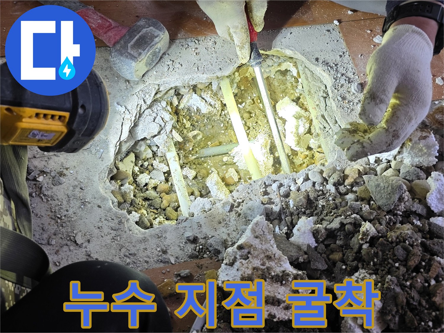 콘크리트 층 아래 드러난 손상된 수도관 부위
