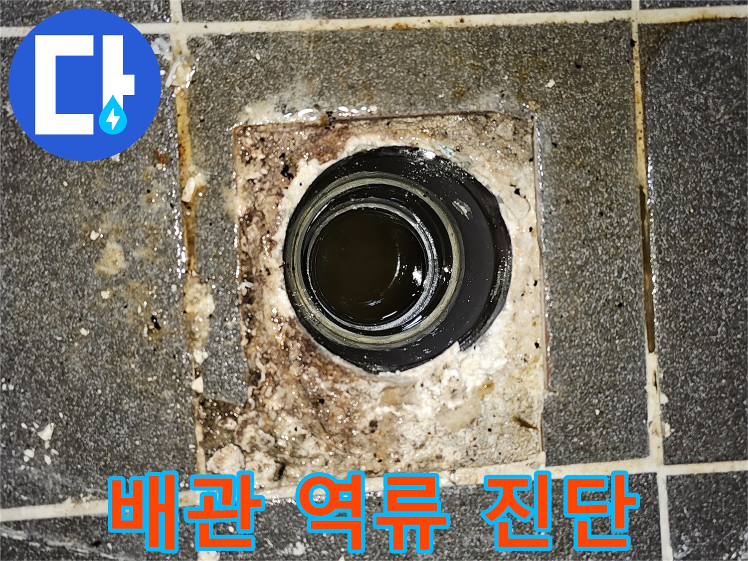 배관에서 오수가 역류하여-바닥에 고여있는 모습을 보여주는-긴급한 누수 상황의 사진입니다.