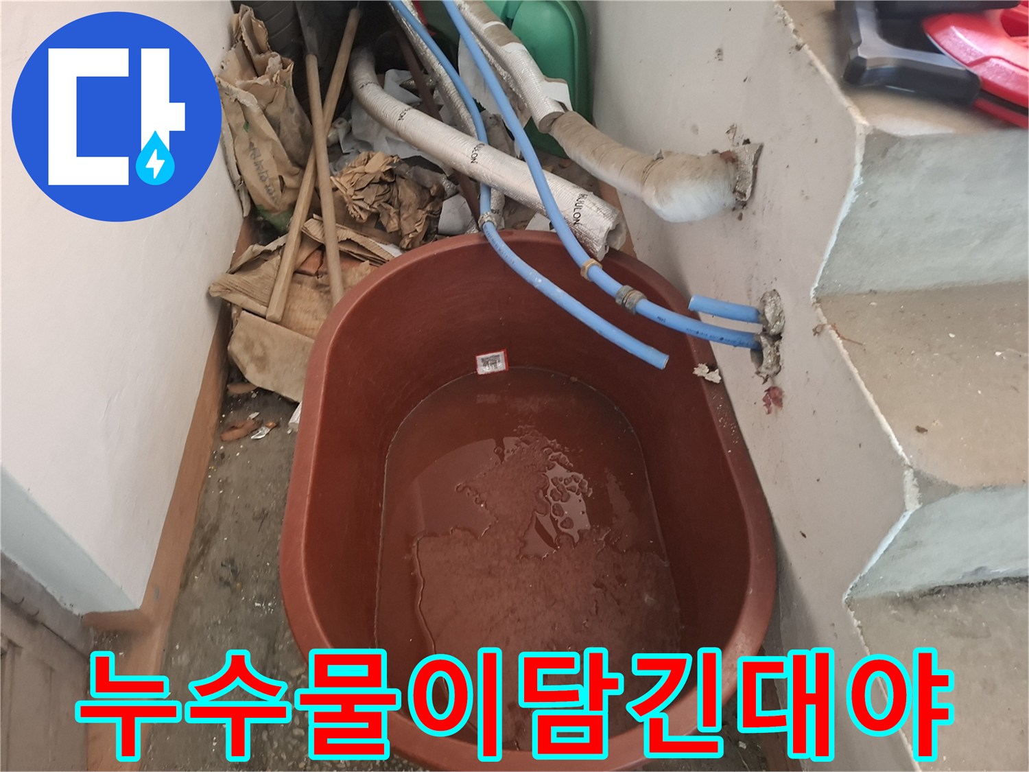 배관에서 새어 나온 물이 담겨 있는 대야와 배관 부위