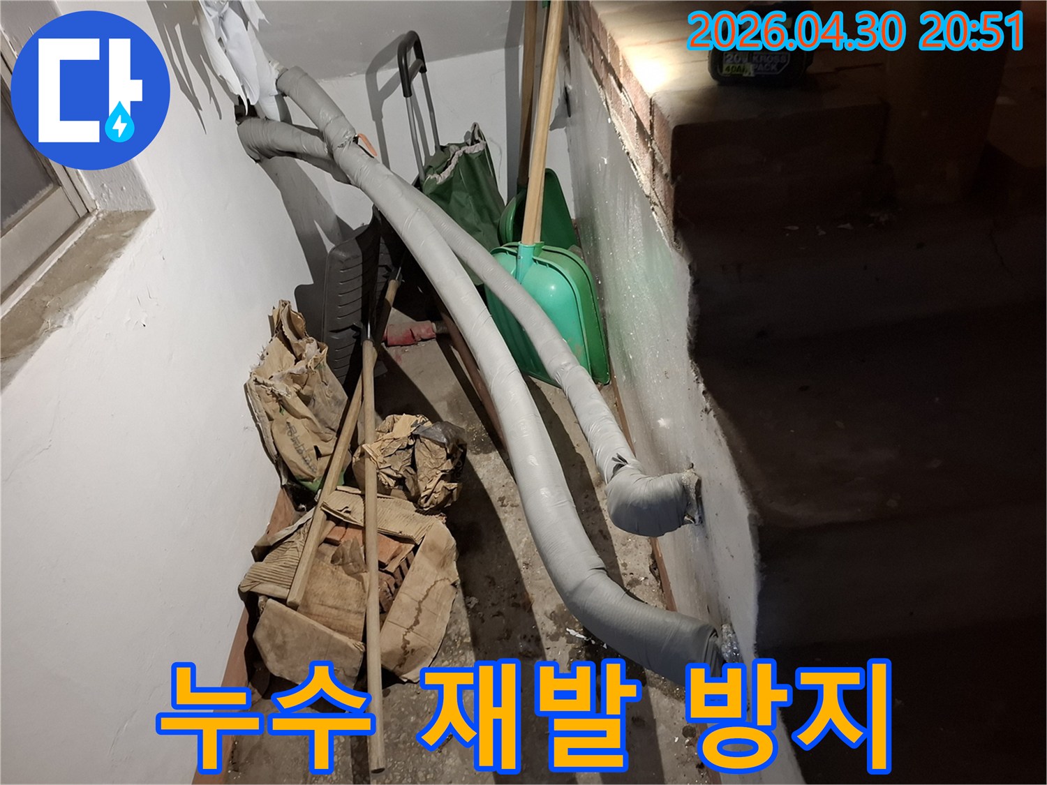 습한 지하 환경 속-단열된 배관과 작업 준비물들이 함께 찍힌 사진입니다.