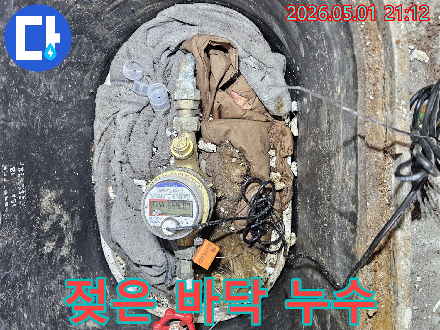 계량기함 주변 바닥이 물에 젖어 있는 모습으로-오랜 시간 누수가 진행되었음을 시사합니다