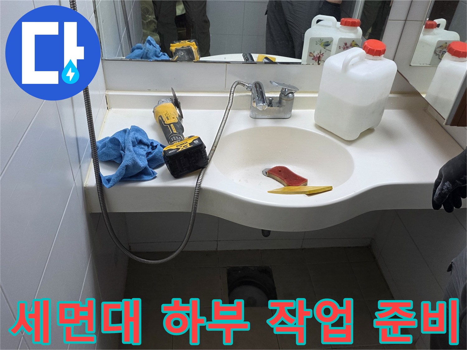 화장실 세면대 아래쪽 배관과 작업용 장비들