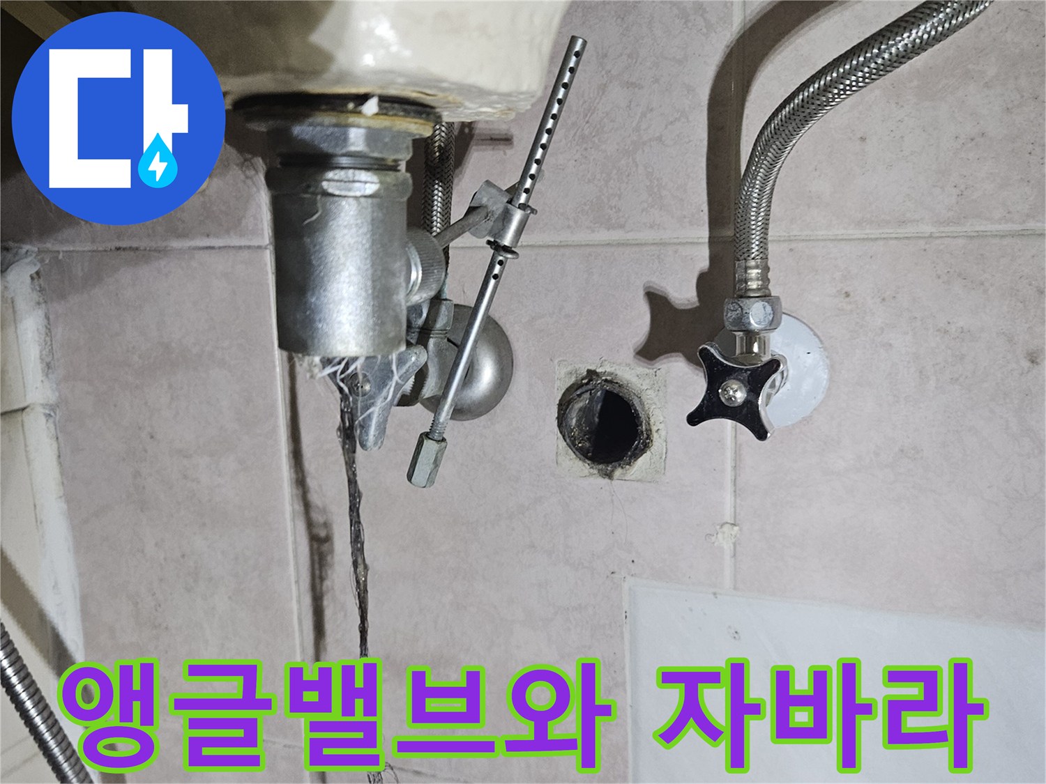 벽면에 설치된 앵글밸브와 세면대 연결 호스의 근접 촬영