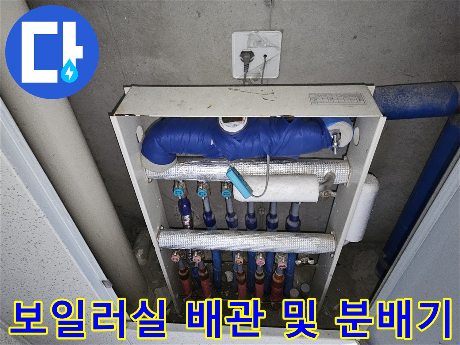보온재로 감싸진 굵은 배관과 하단의 분배기 부속들