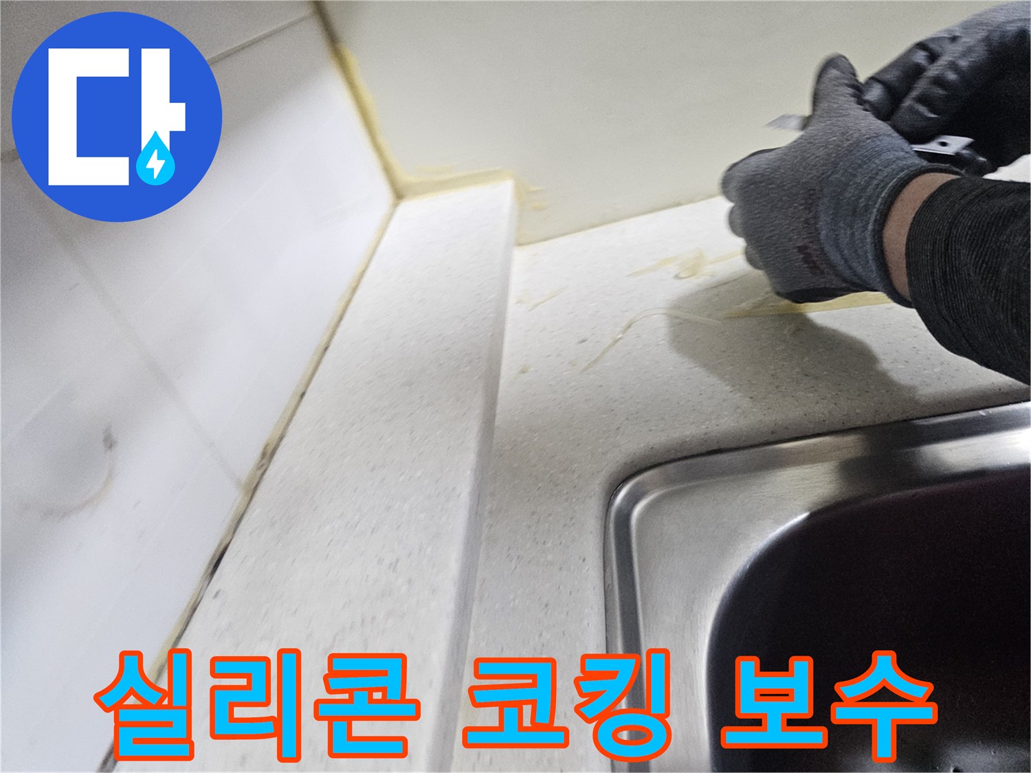 장갑을 낀 작업자가 싱크대 벽면 틈새를 만지는 사진