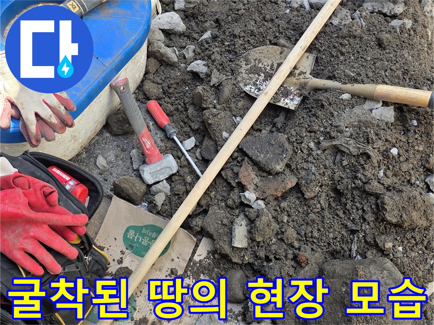 파헤쳐진 흙과 돌 사이의 작업 도구 - 누수 수리를 위한 굴착 부위