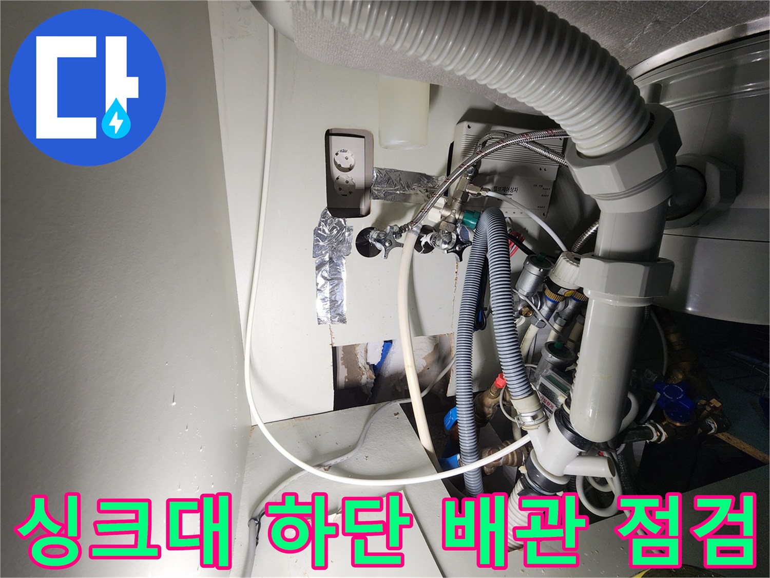 싱크대 밑부분의 굵은 호스와 연결된 급수 배관들