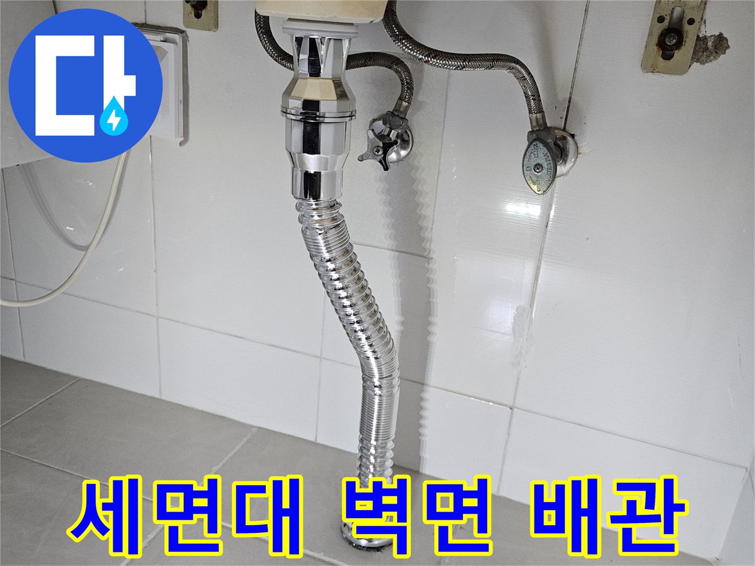욕실 타일 벽면에 설치된 세면대 배수관 부위