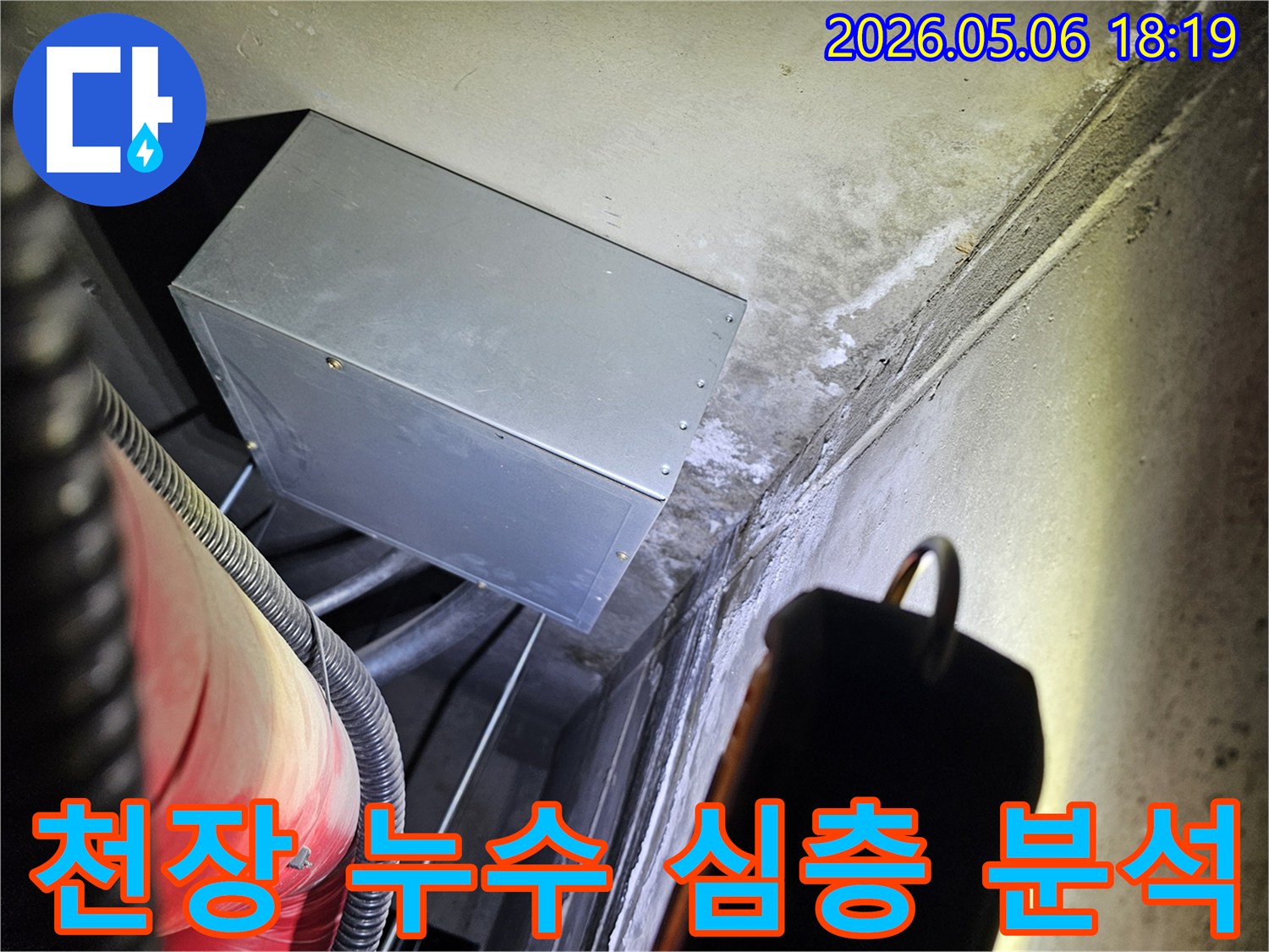 어두운 공간에서-천장과 벽면의-누수 흔적을-손전등으로 비춰-심층 분석하는-전문가의 모습입니다.