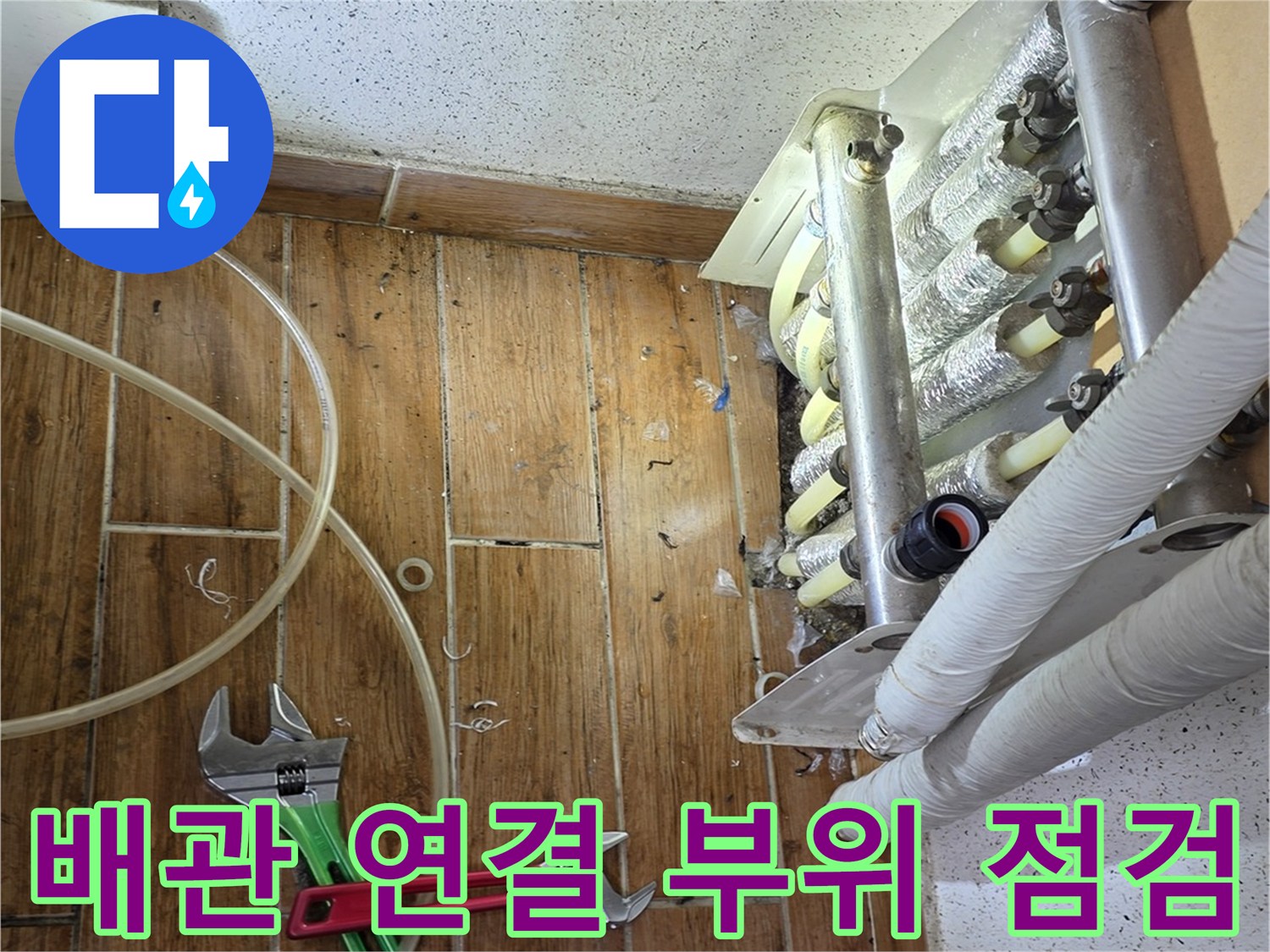 스패너와 배관공구를-사용하여-분배기-연결부를-점검하는-장면