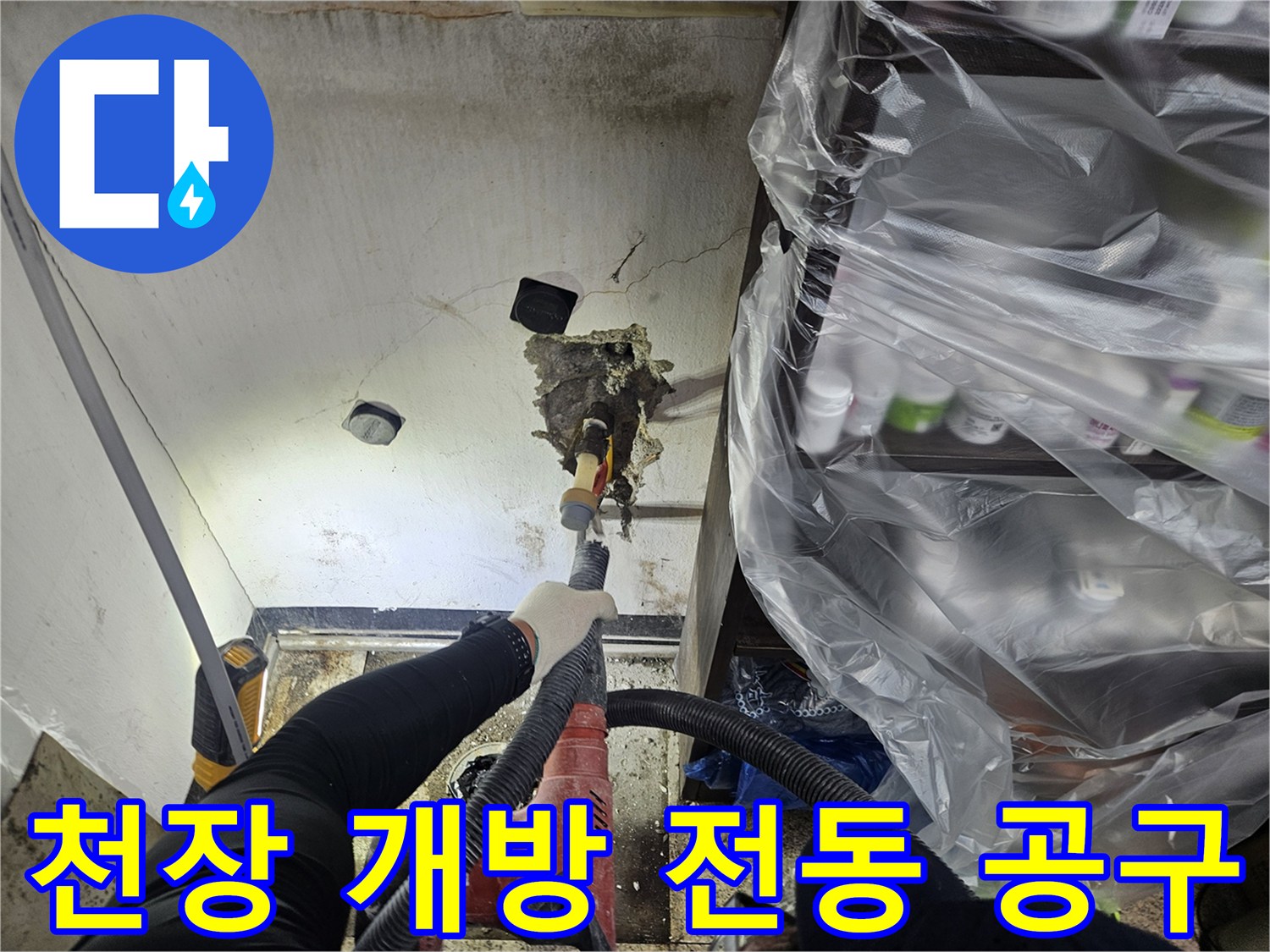 숙련된 작업자가-누수 원인을 정확히 파악하기 위해-전동 공구를 사용하여 천장 일부를 조심스럽게 타공하고 있습니다