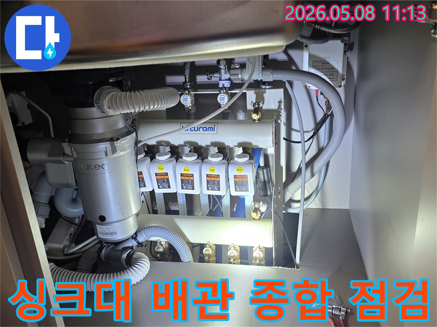 싱크대 하부의-복잡한 배관 시스템과-정수기-음식물처리기 주변을-전문가가 종합적으로-점검하고 보수하는-작업 현장입니다
