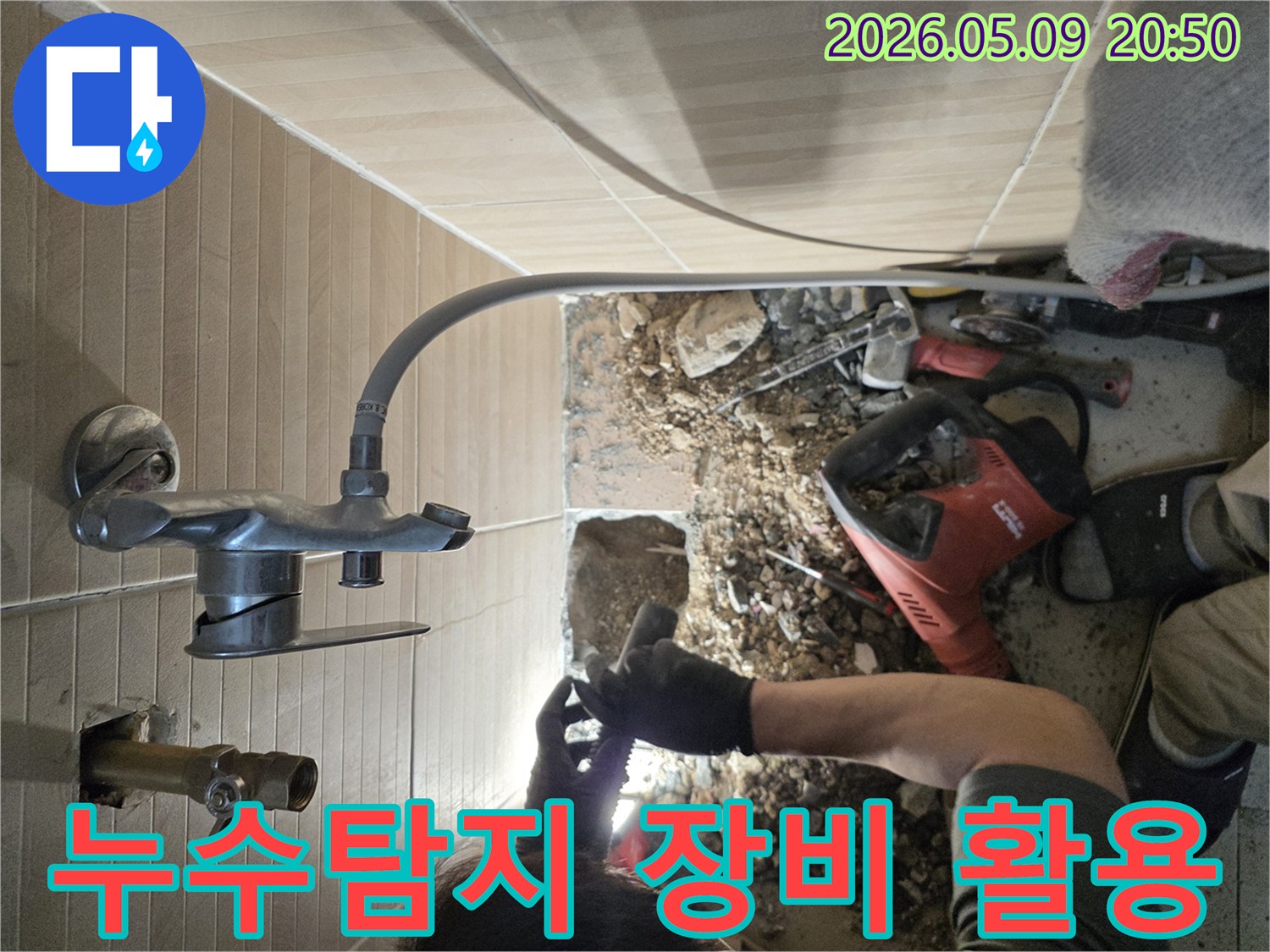 이 이미지는-성남 수정구의 한 빌라에서-누수 문제를 해결하기 위해-전문가가 최신 누수탐지 장비를-활용하여-정확한 누수 지점을-찾아내는 과정을 보여줍니다.