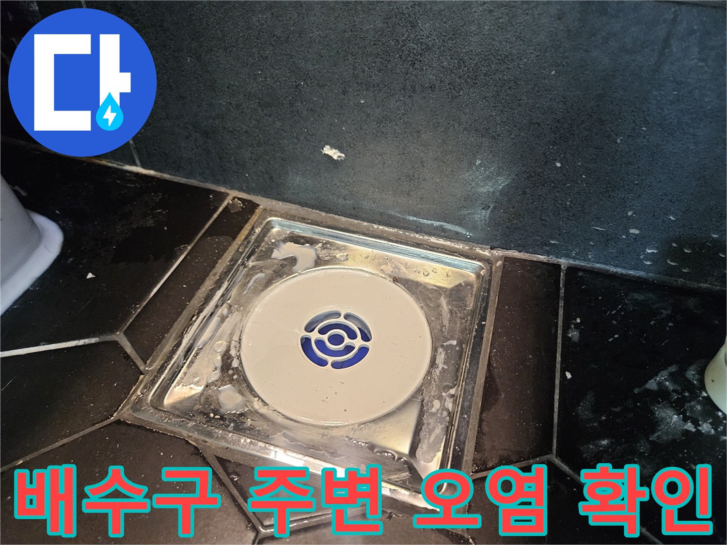 검은색 타일과 흰색 배수 트랩의 경계 부위 촬영