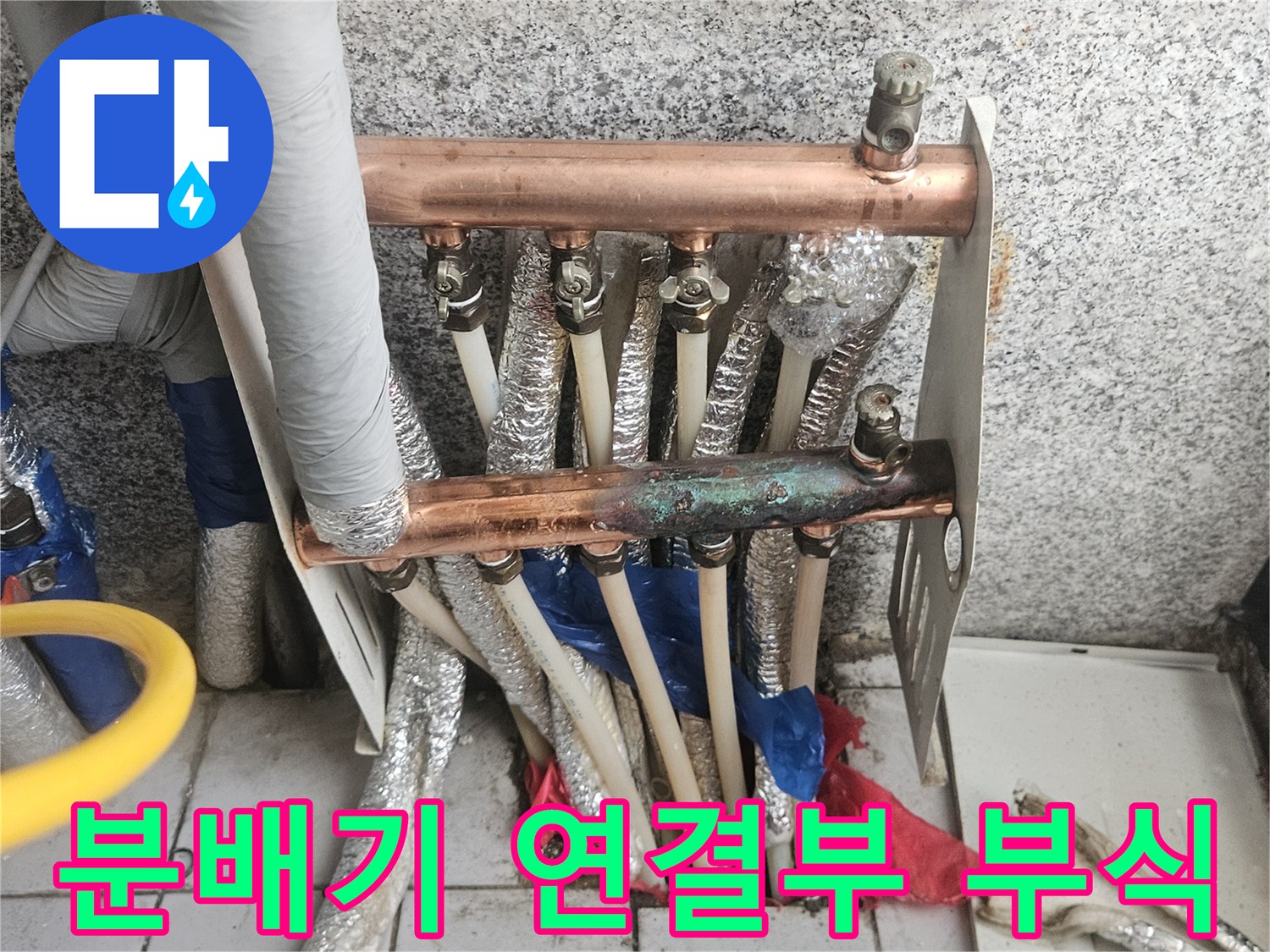 누수로 인해 변색되고 부식된 구리 배관과 분배기 밸브