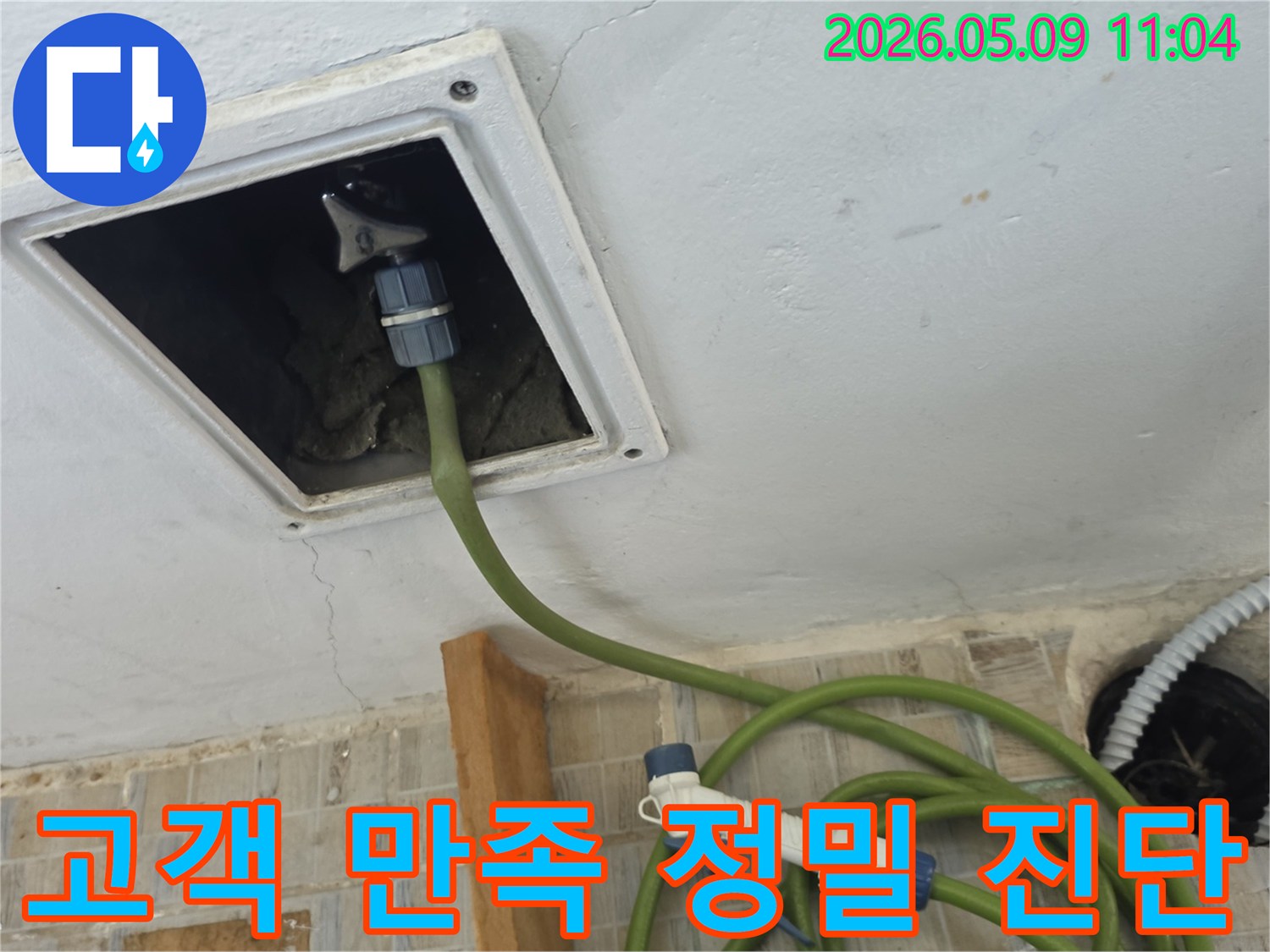 천장 점검구에 누수 탐지 호스를 연결하여 고객 만족을 위한 정밀 진단을 수행하는 모습