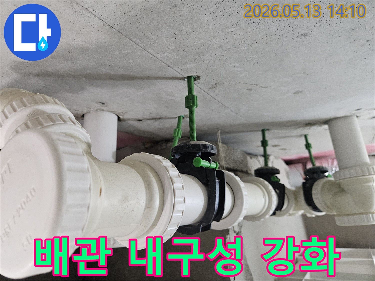 콘크리트 천장에 견고하게 설치된 흰색 배관과-검은색 밸브들이 튼튼하게 연결된 모습
