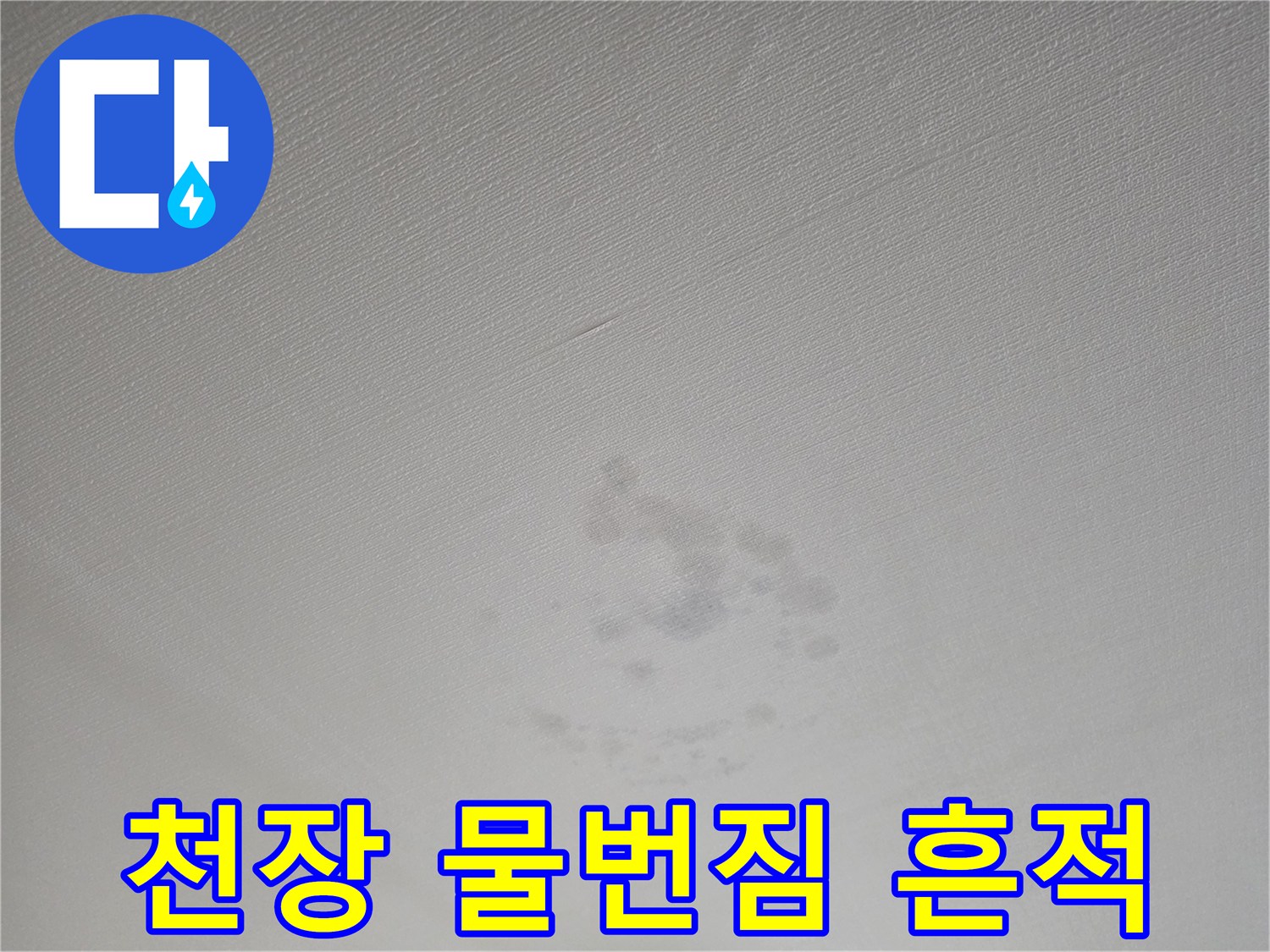 천장 마감재에 나타난 짙은 색의 누수 얼룩 사진