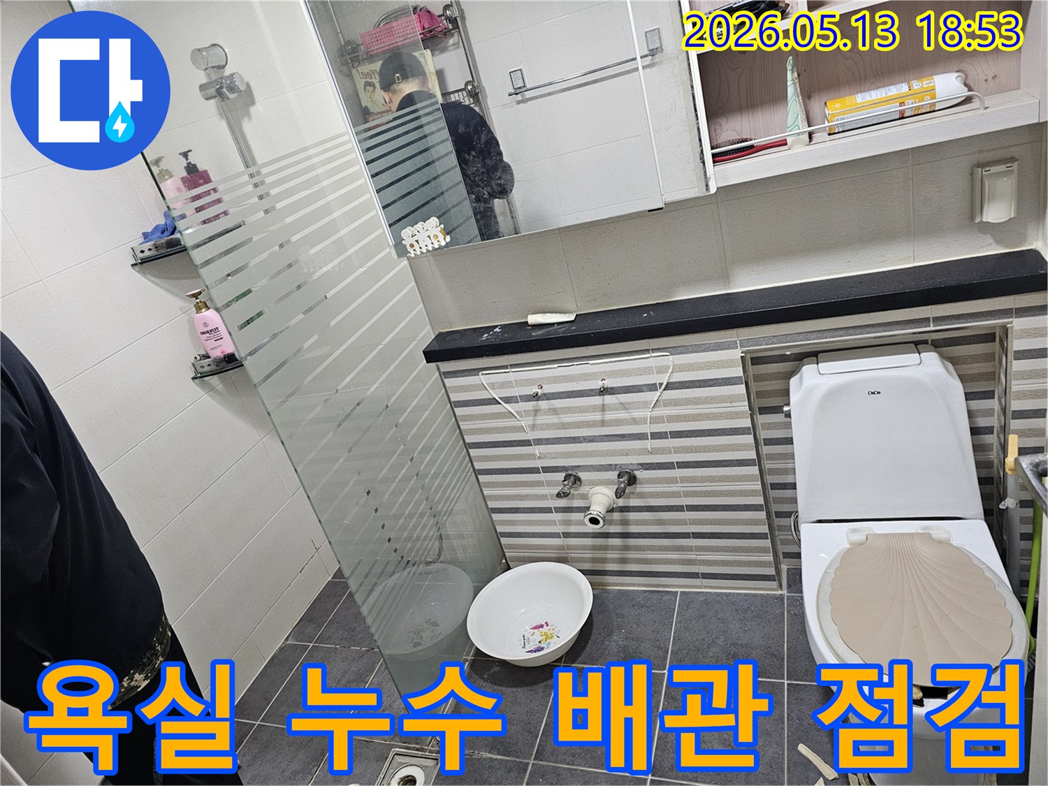 이 이미지는-인천 연수구의 한 아파트 욕실에서-세면대 배관 누수 점검을 위해-설비가 제거된 상황을 보여줍니다.