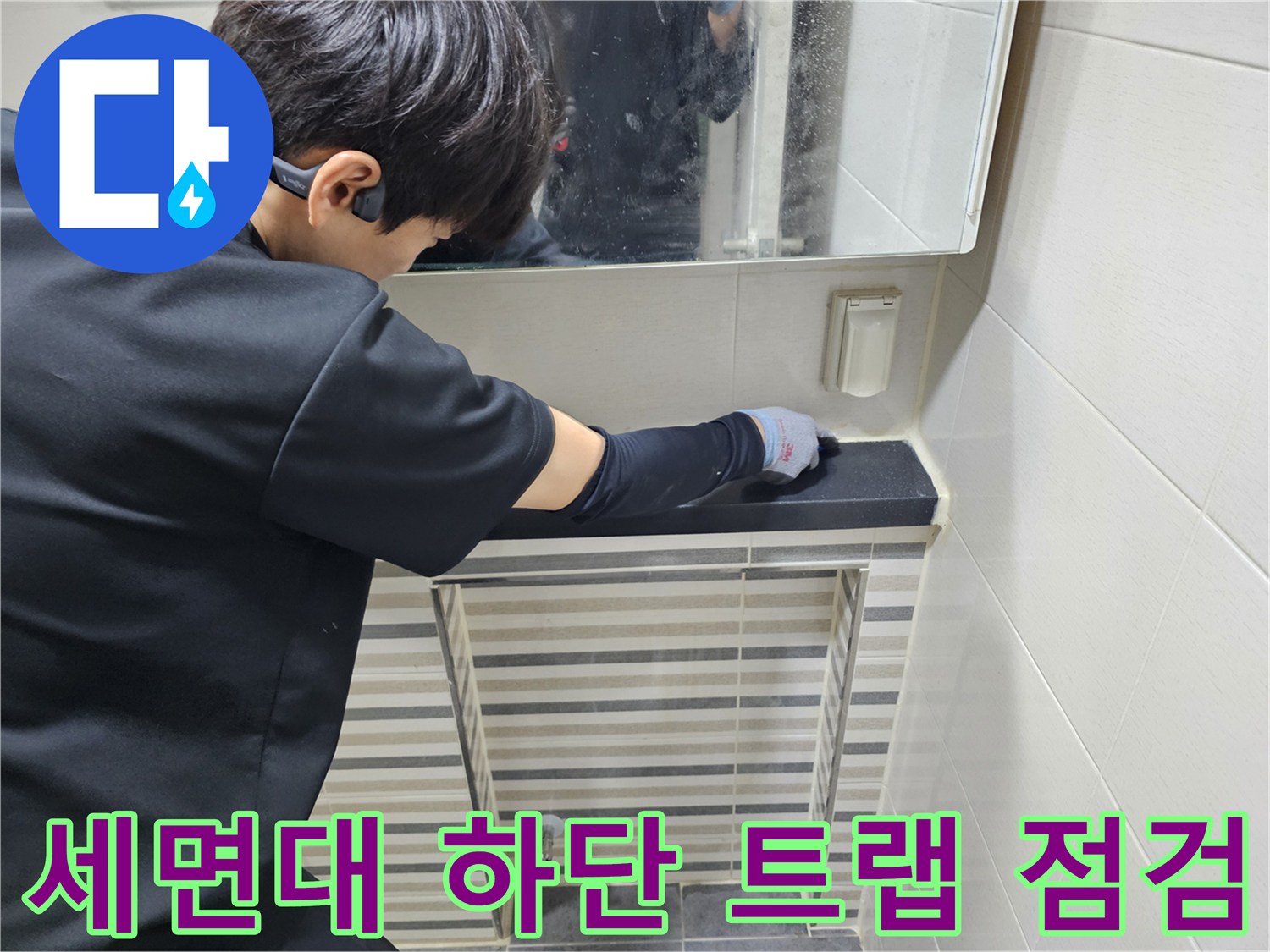 작업자가 세면대 아래쪽의 연결 부위를 손으로 만지며 상태를 살피고 있습니다.