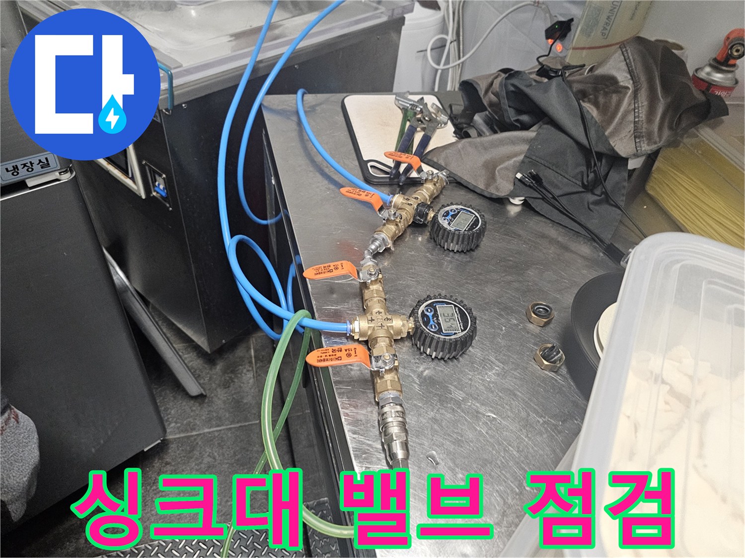금속 밸브와 연결된 파란색 및 초록색 급수 호스