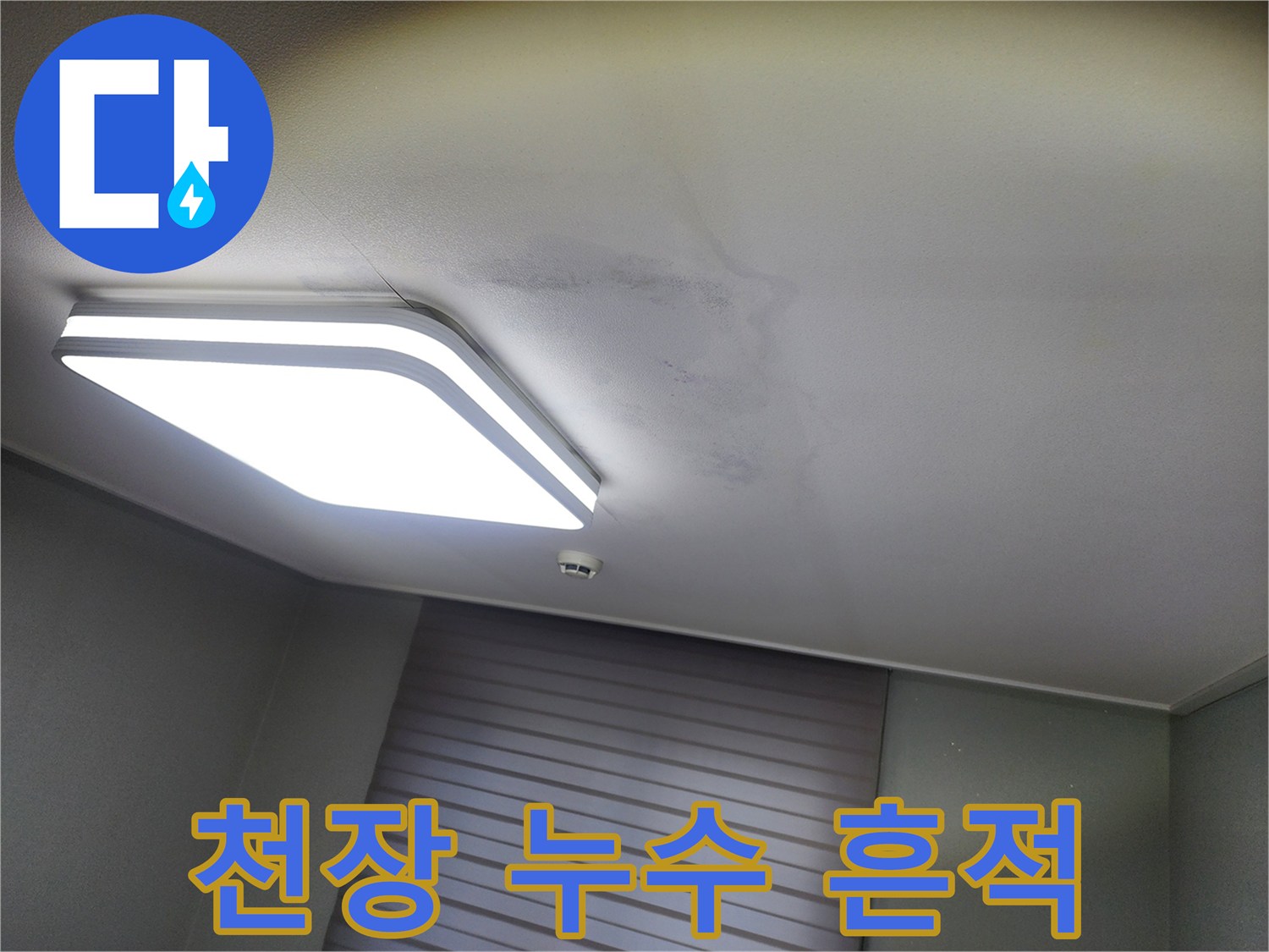 천장 조명 주변에 나타난 어두운 색의 누수 오염 부위