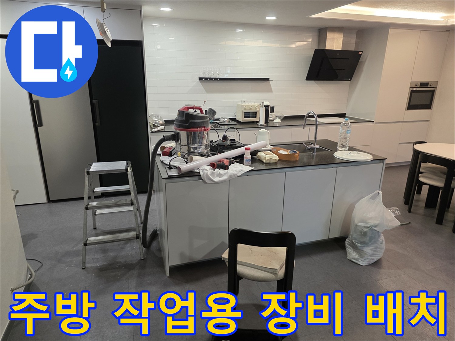 싱크대 아래 바닥에 놓인 청소기와 각종 공구들
