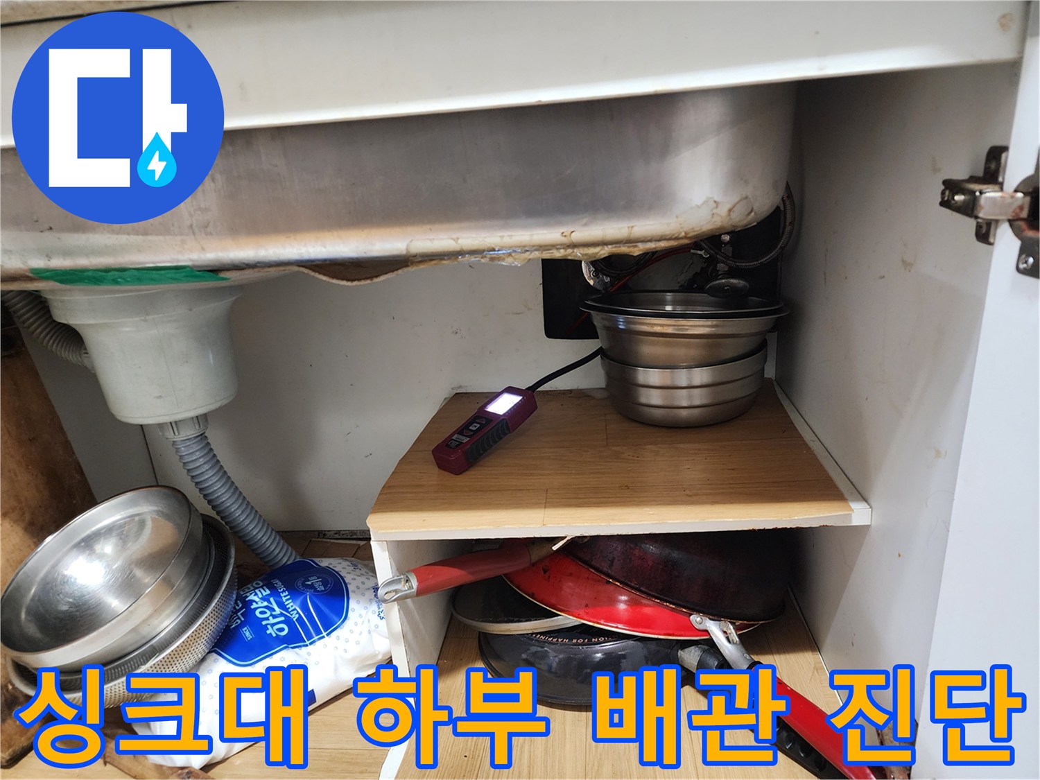 주방 싱크대 밑-디지털 장비로 배관의 기밀성을 테스트 중