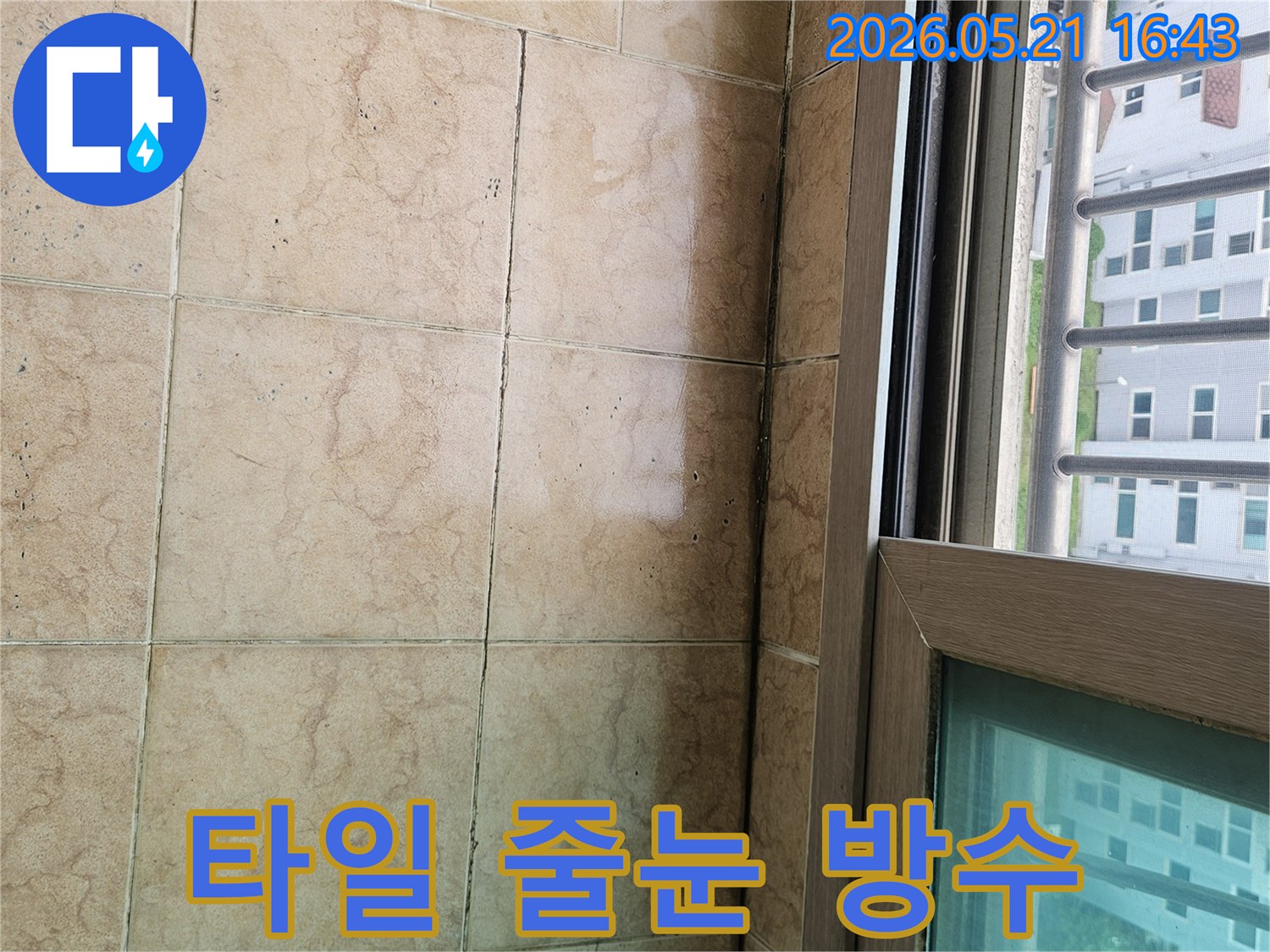 아파트 베란다-타일 줄눈에-보이는 어두운 변색은-줄눈 사이로-물이 스며들어-발생한 누수 흔적을-나타내고 있습니다.