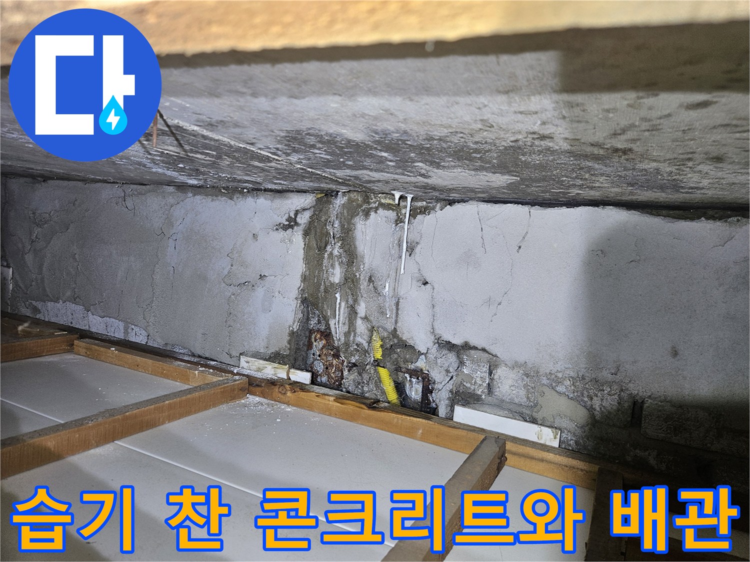 물이 고여 있는 듯한 콘크리트 틈새와 노란색 배관 부위