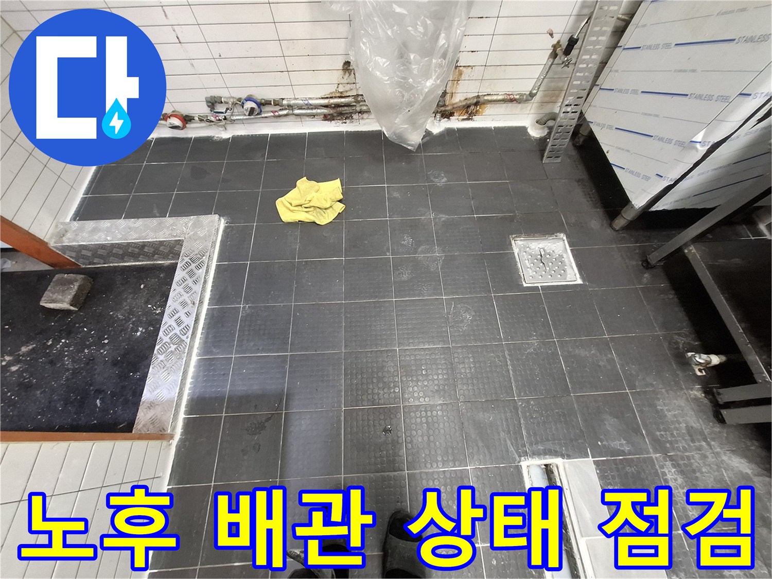 벽체 하단에 노출된 수도 배관과 주변 타일의 습기 상태