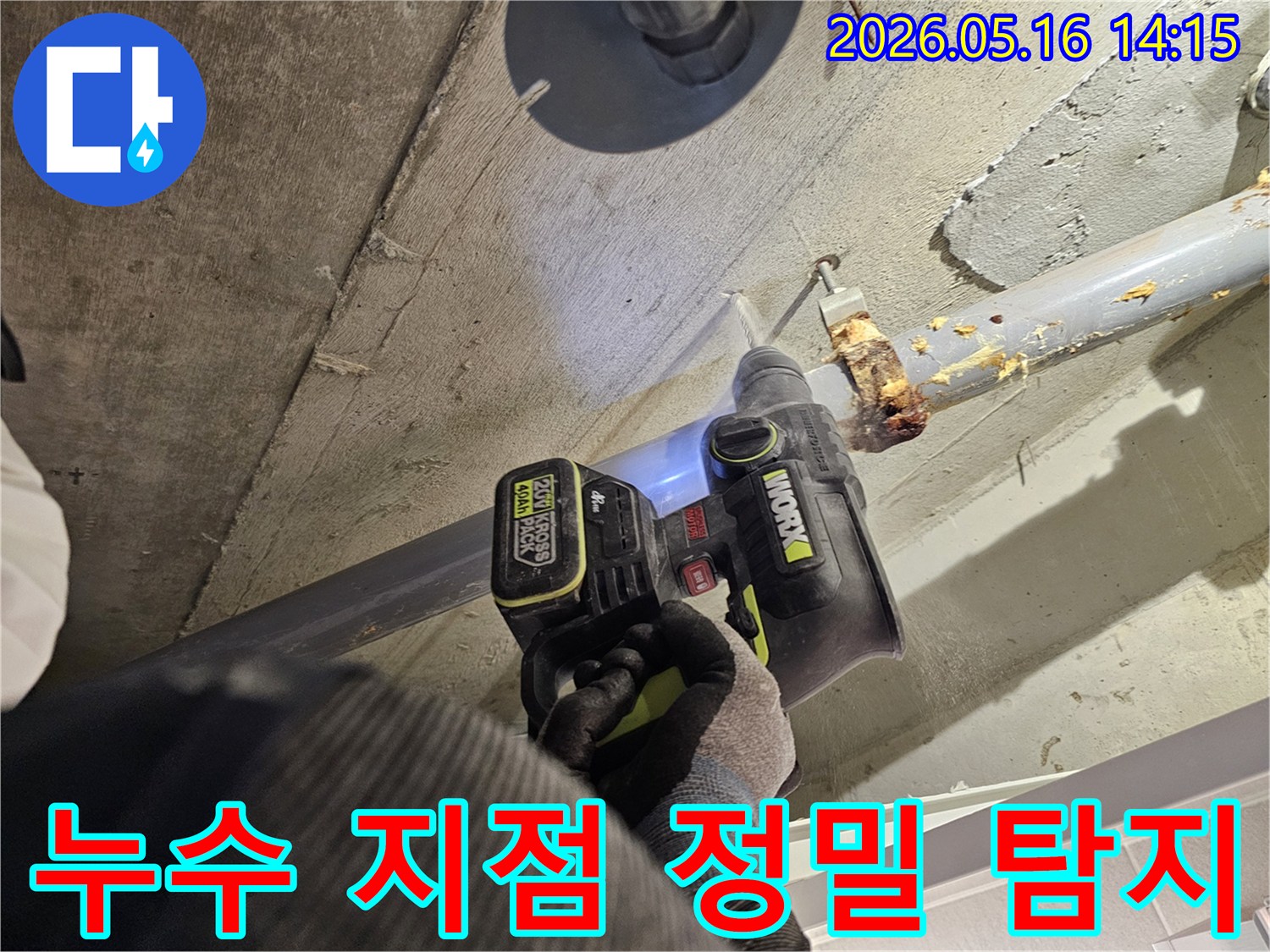 누수 전문가가 천장 배관의 누수 지점을 정밀하게 탐지하기 위해 드릴로 콘크리트를 타공하는 모습-정확한 진단을 위한 작업입니다.