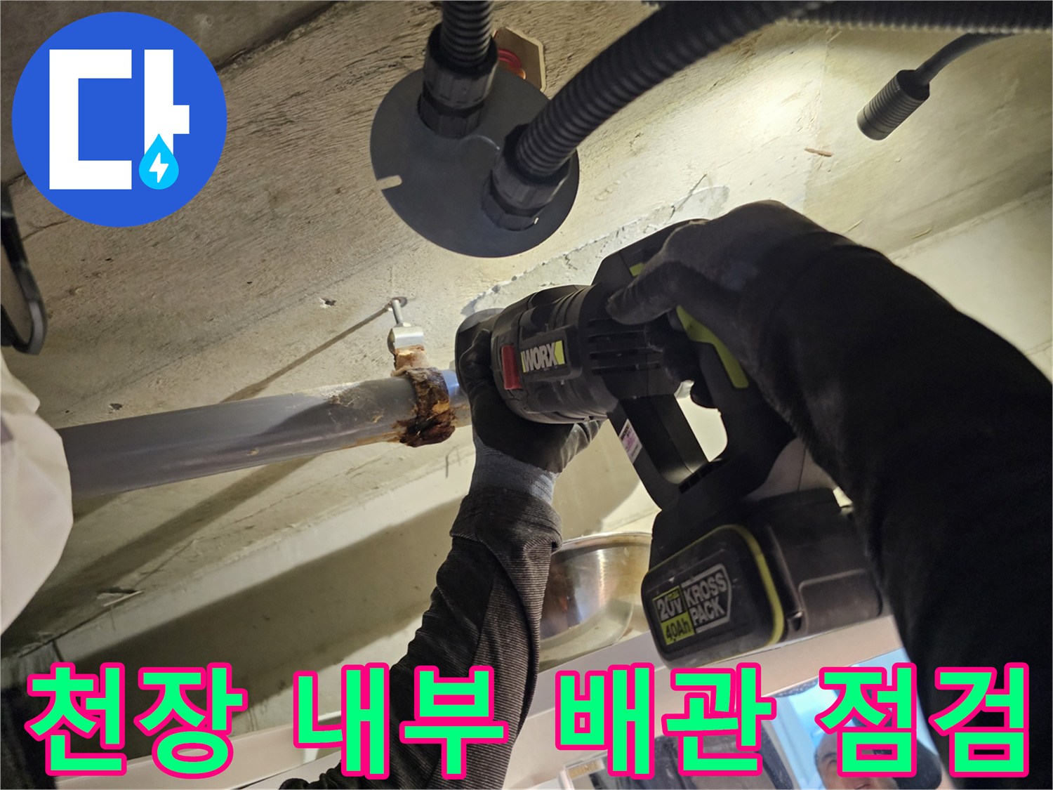 전동 공구로 오수관 연결 부위를 세밀하게 확인하는 작업자
