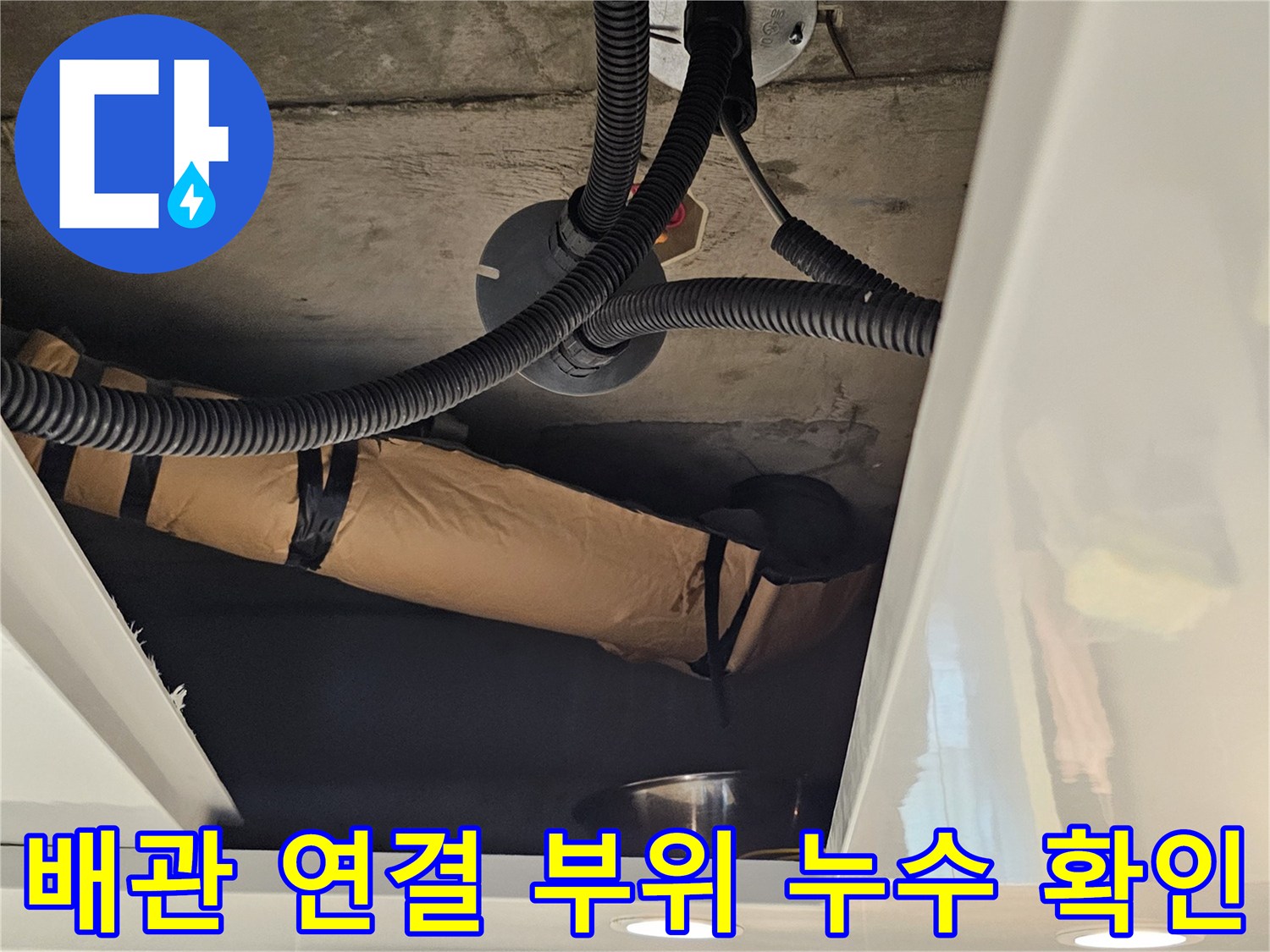 천장 점검구를 통해 촬영한 검은색 주름 배관의 접합부