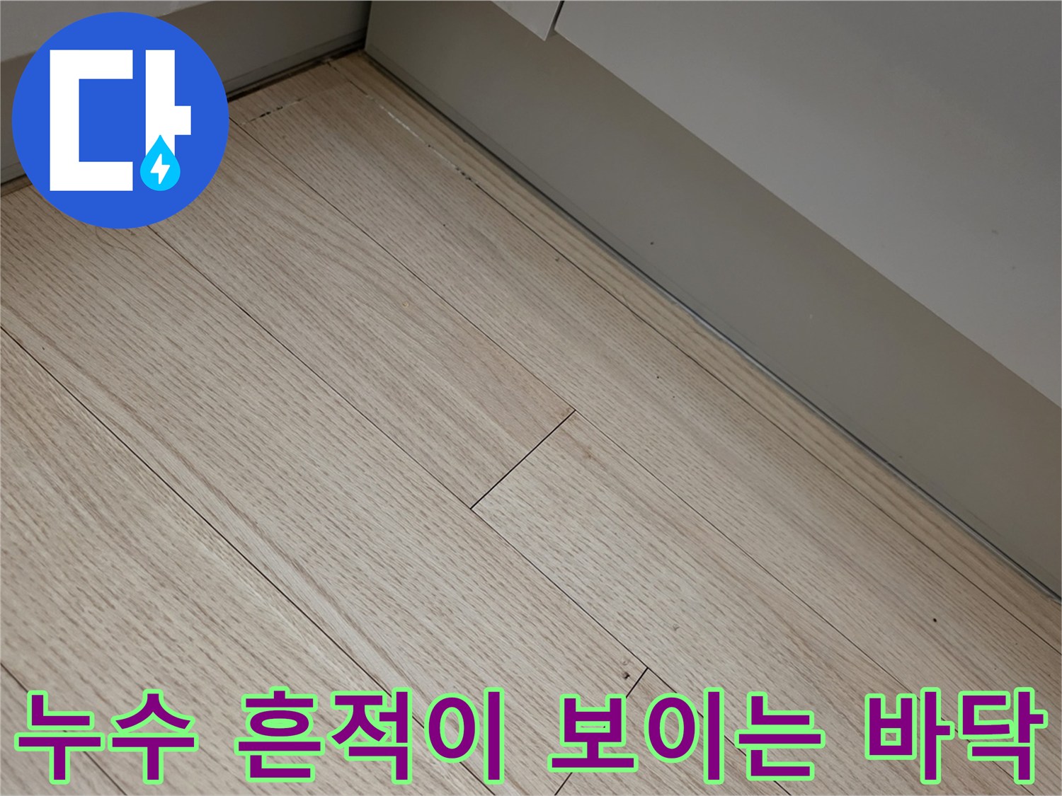 싱크대 하단 마루판의 습기 침투 및 변색된 상태 사진