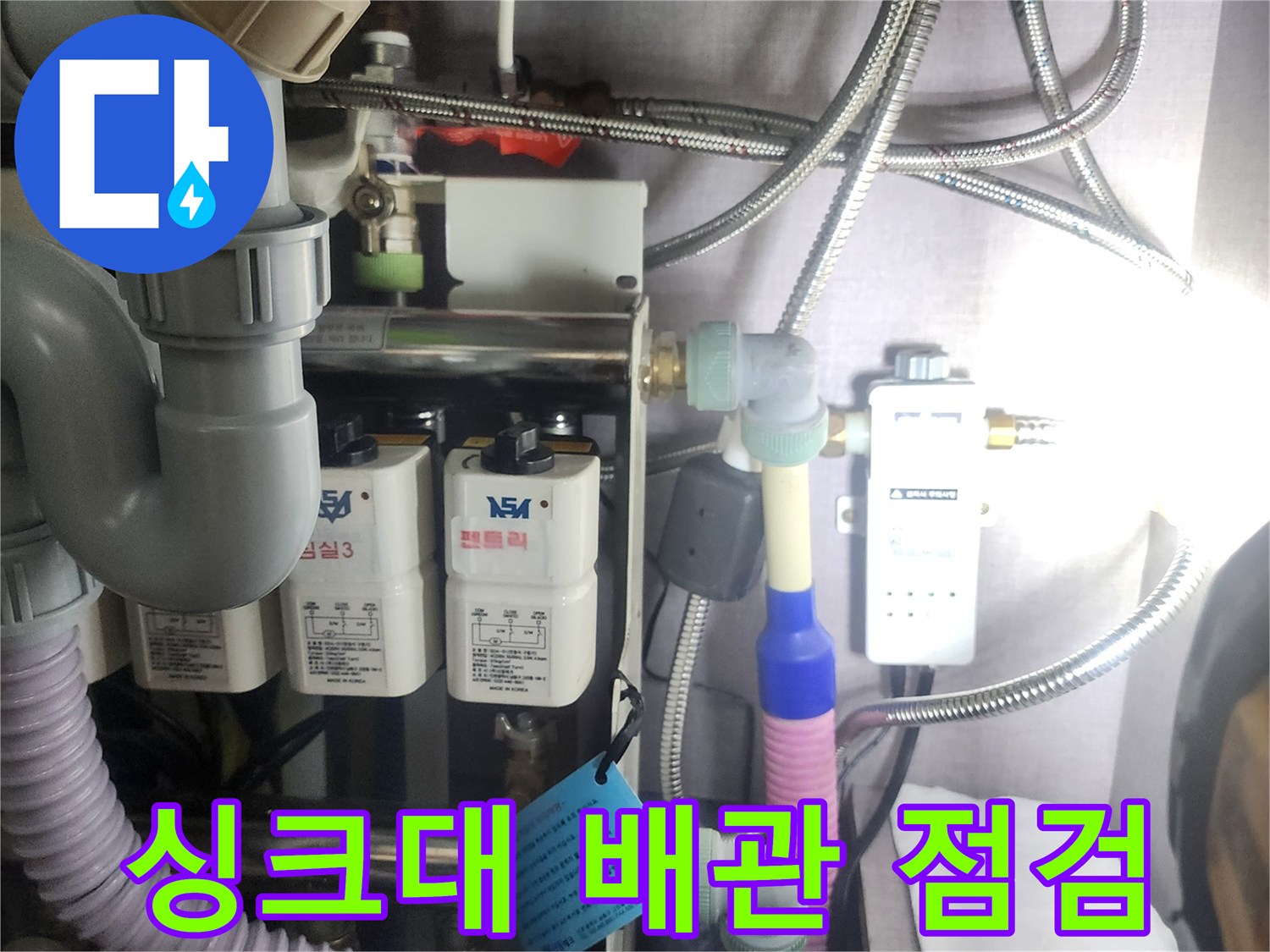 싱크대-하부장-내부의-복잡한-배관과-수전-연결부-상태