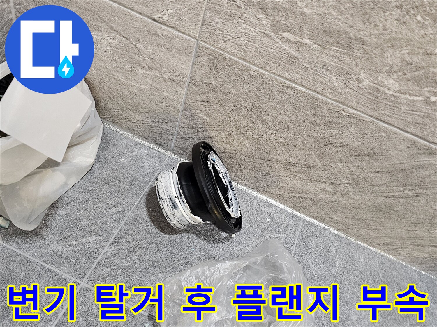 변기 탈거 작업 중 드러난 오수관 연결용 플랜지 부속품과 바닥 타일 상태