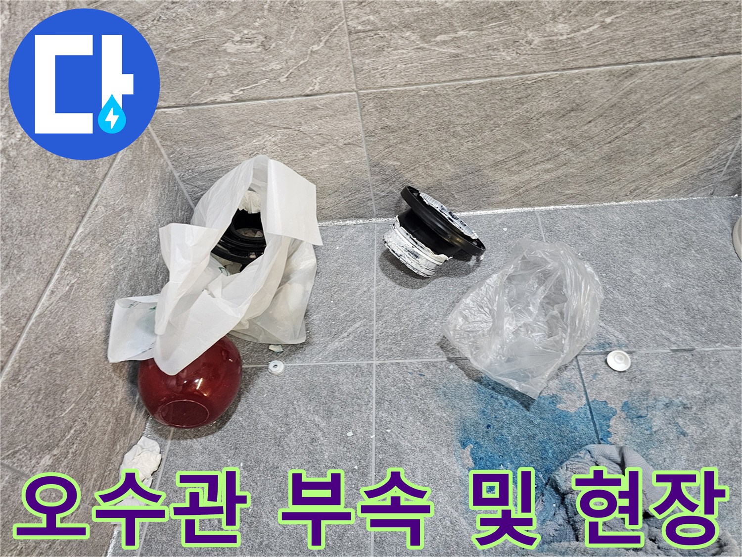 탈거된 변기 배관 주변의 젖은 타일과 교체용 부속품