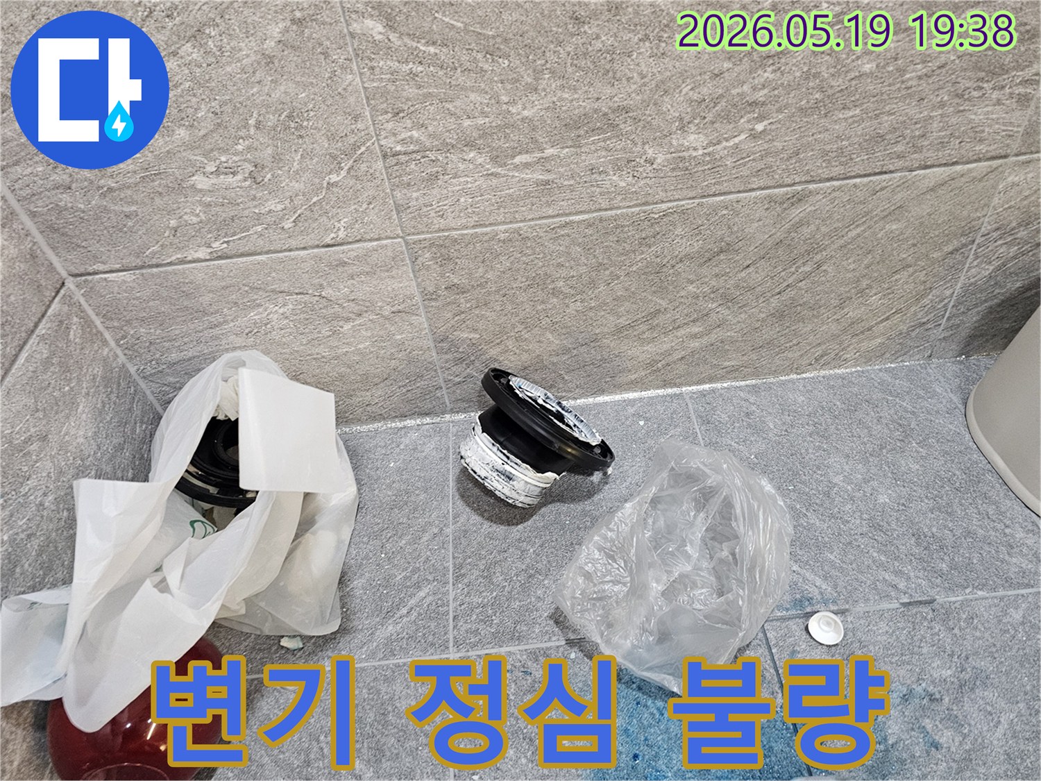 화장실 바닥에 버려진-오래된 변기 정심과-주변에 퍼진 푸른색 오염 물질