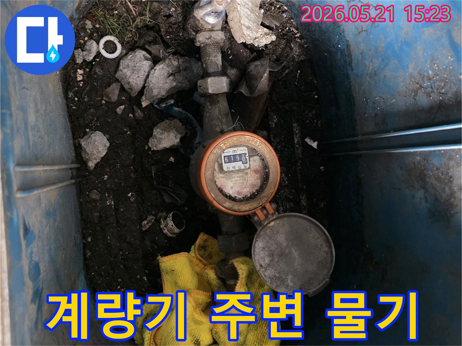 누수-의심-현장에서-수도-계량기-주변의-노란-천과-물기를-점검하는-모습