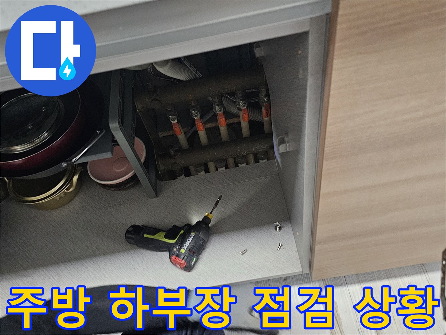 싱크대 하부의 수납물들을 정리하여 배관을 노출시킨 현장 사진