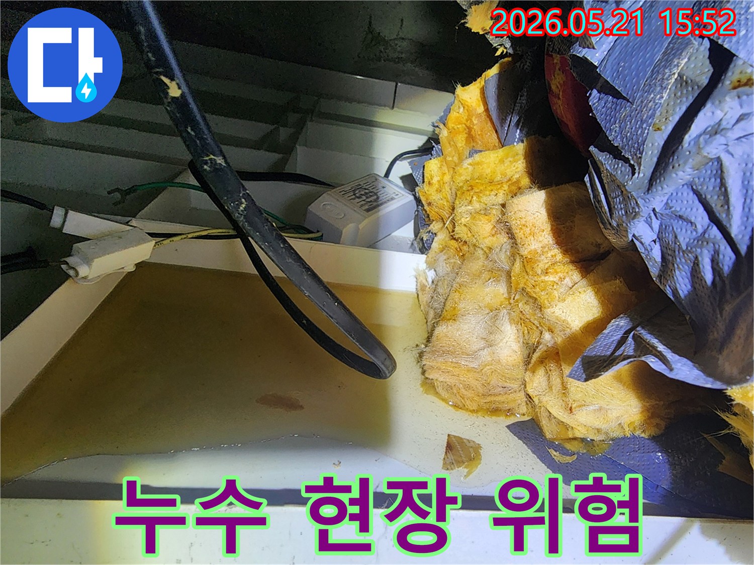 천장 누수로 인해-물에 젖은 단열재와-노출된 전기 배선 등-잠재적 위험 요소를-보여주는 현장 사진입니다