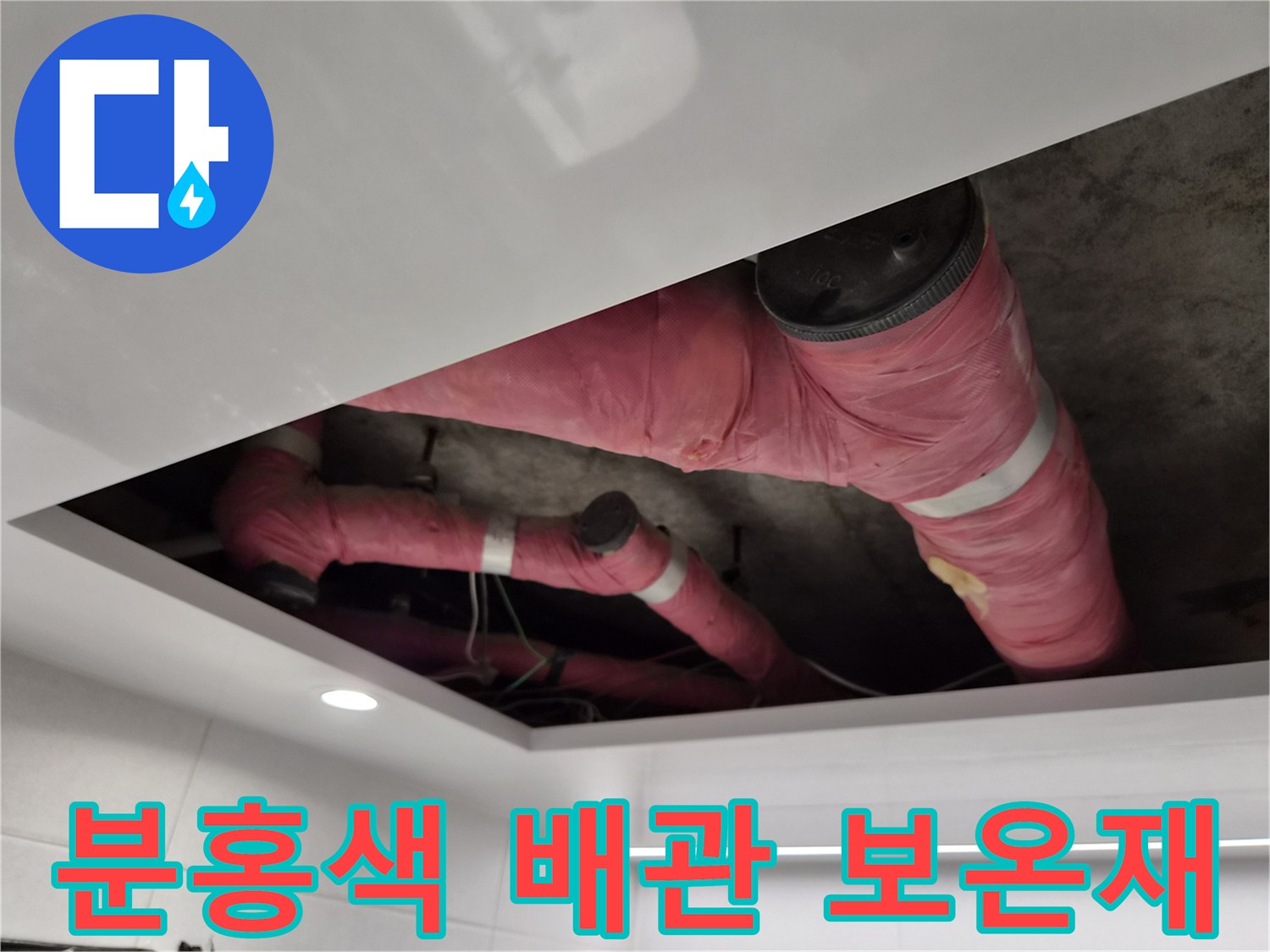 분홍색 보온재로 덮인 천장 내부 배관의 복잡한 구조
