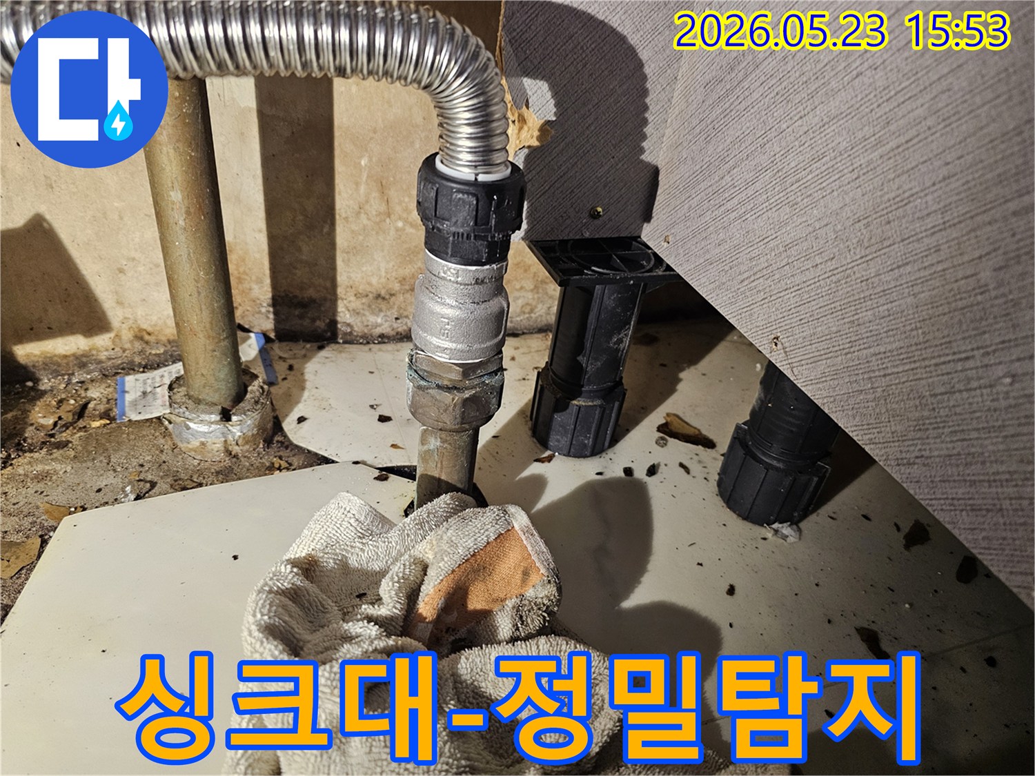 싱크대 하부 배관에서 물이 새어-바닥에 젖은 수건이 놓인-정밀 탐지 현장 사진