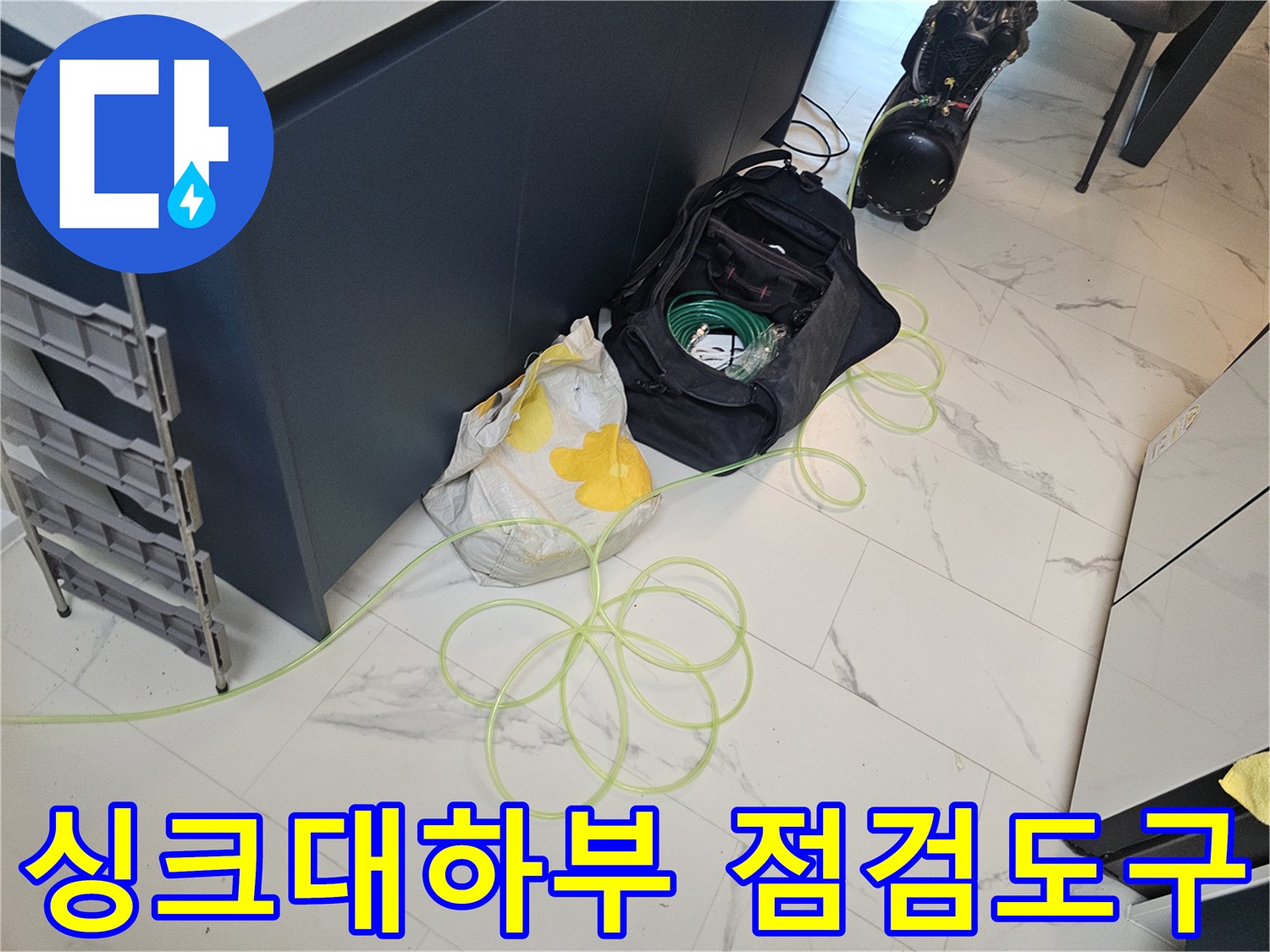 싱크대-하부장-바닥에-놓인-누수-점검-장비와-자재