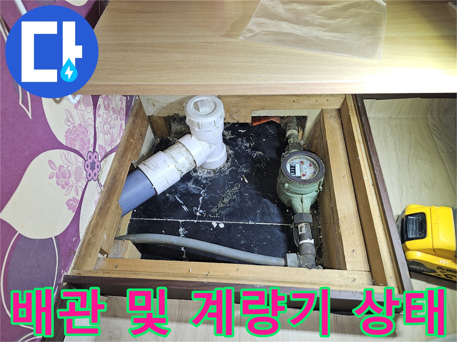 싱크대 하단부에 노출된 수도 계량기와 연결된 급수 배관의 모습입니다.