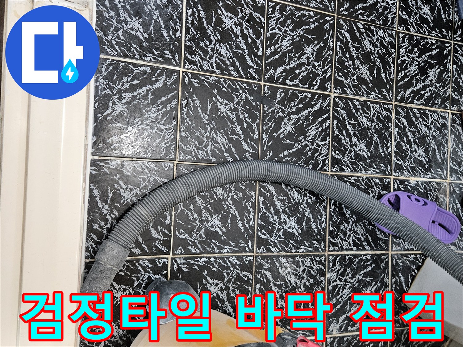 검은색 패턴 타일 위에 놓인 청소 장비와 호스